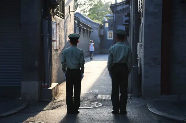 在北京的核心地带,两名警卫正在一条胡同内执勤。