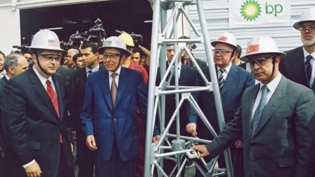 Счастливые люди в касках и галстуках вокруг декоративной скважины. В центре Гейдар Алиев