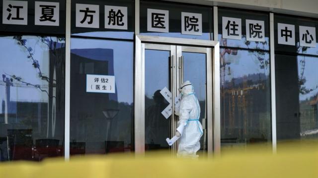 A medical worker seals the doors of Hongshan Gymnasium, one of the temporary hospitals for COVID-19 patients, in Wuhan in central China's Hubei province Tuesday, March 10, 2020. The city has shut down 14 temporary hospitals amid the drop of new COVID-19 cases.- PHOTOGRAPH BY Feature China / Barcroft Studios / Future Publishing (Photo credit should read Feature China/Barcroft Media via Getty Images)