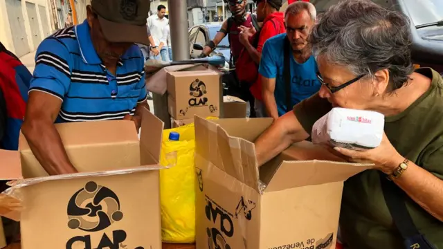 Venezuelanos abrindo caixas CLAP.