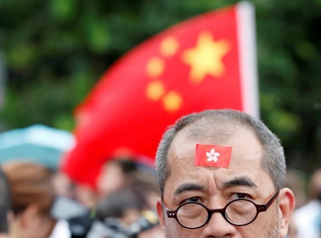 香港撑警集会现场，有群众手举中国国旗。