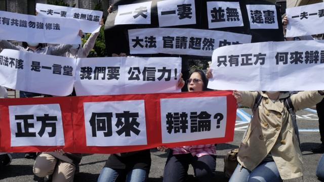 反对同婚人士3月24日宪法法庭开庭日在司法院外举标语抗议。