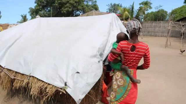 Une femme, appelée Elsa par le groupe d'aide britannique Save the Children, marche avec un enfant dans un camp de déplacés de la province de Cabo Delgado, au nord du Mozambique.
