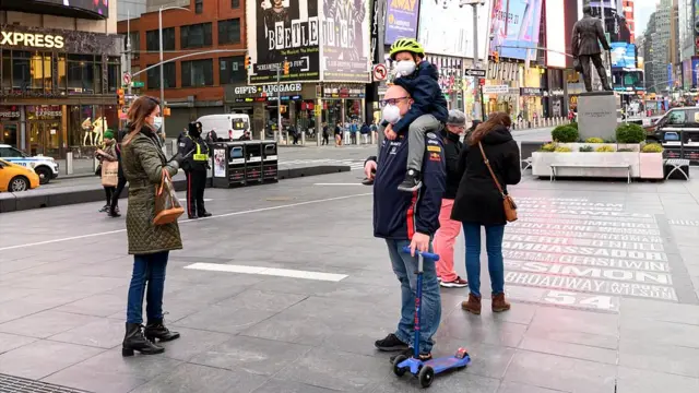 Pessoas com máscaras no rosto na Times Square,chute no alvo betanoNova York