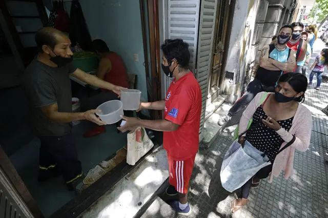 Personas haciendo fila en un comedor comunitario