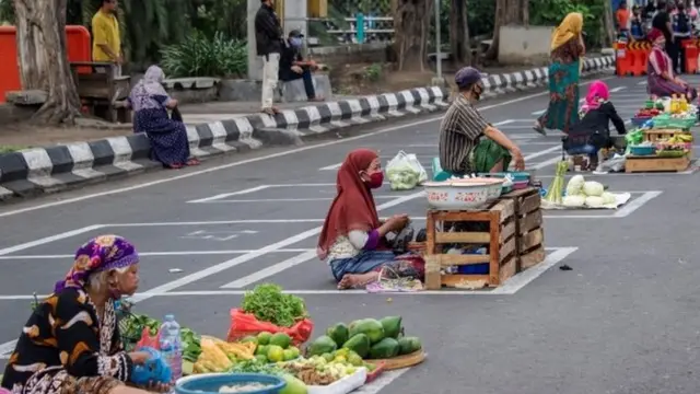 Penjual sayuran di satu jalan di Surabaya, menjaga jarak.