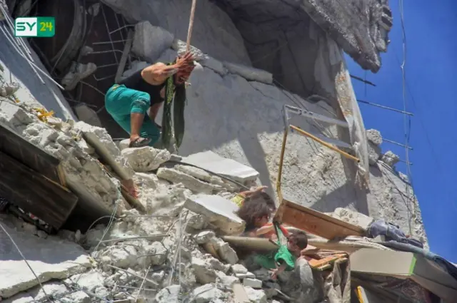 Foto de menina que tenta salvar irmã após bombardeio na Síria