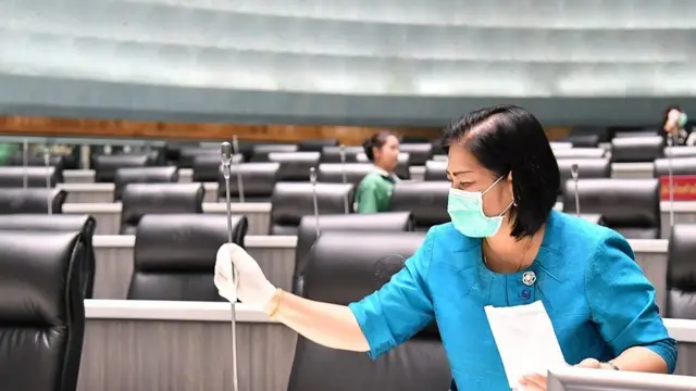 Mulher limpa microfone no parlamento tailandês