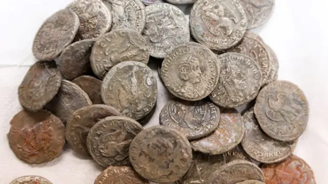 Des pièces de monnaie romaines antiques trouvées dans une épave en mer Méditerranée sont exposées dans les laboratoires de l'Autorité israélienne des antiquités à Jérusalem (22 décembre 2021).