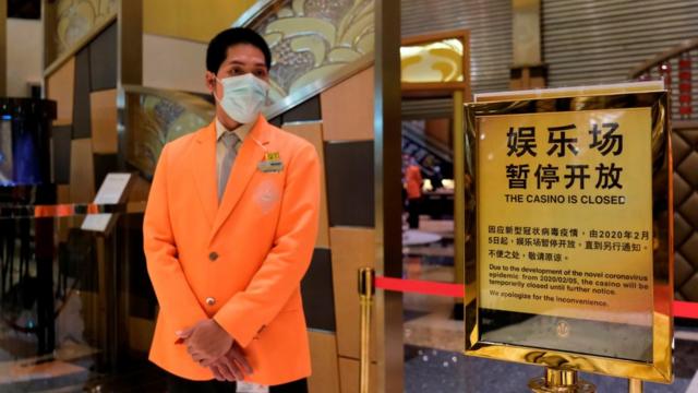澳门新葡京赌场一名员工看守已拉起封锁线的赌厅入口（4/2/2020）