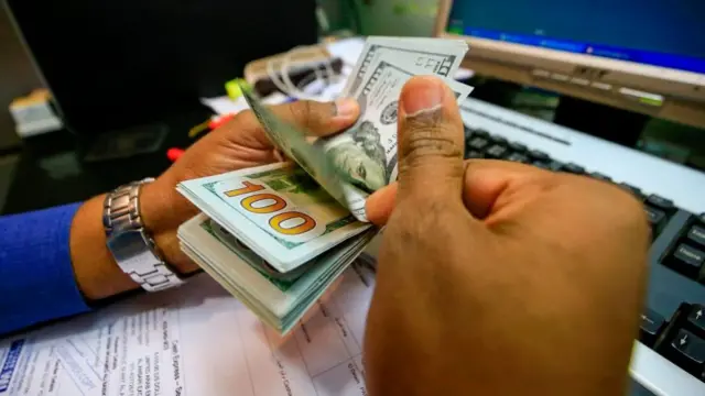 شخص يعد دولارات