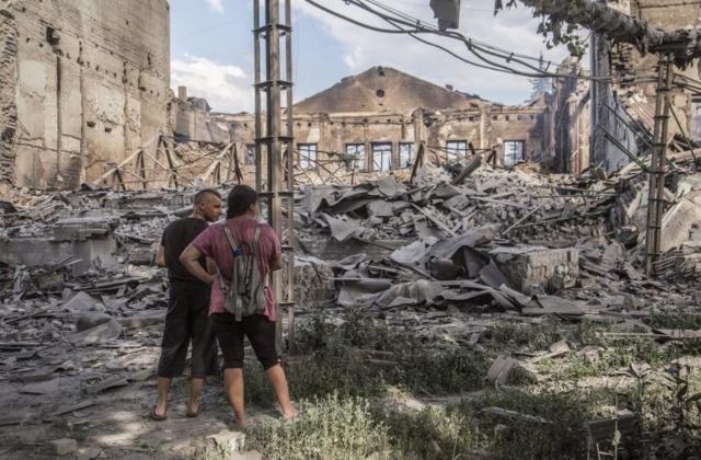 Locals look at destroyed buildings in Lysychansk after heavy fighting in the Luhansk area, Ukraine,