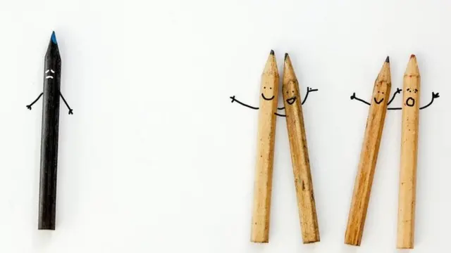 Un lápiz negro separado de otros cuatro.