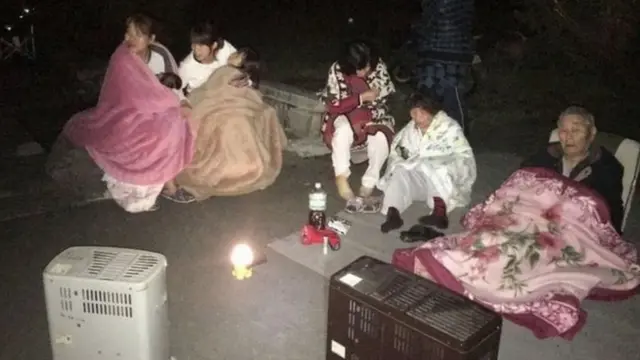 道路に避難し毛布とストーブで暖をとる人たち（15日）