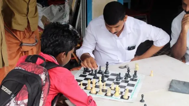Un joven y un hombre jugando ajedrez
