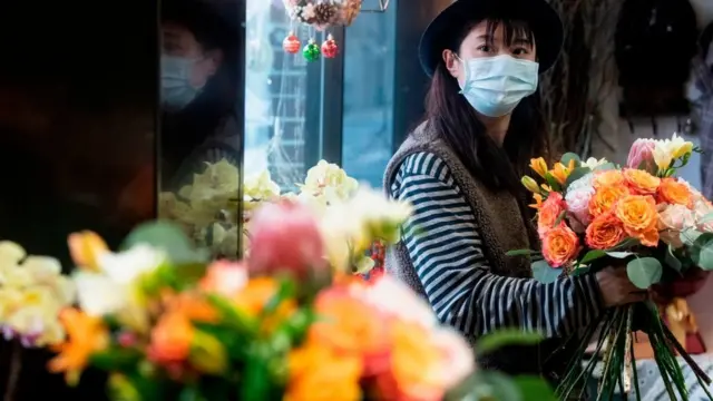 ভ্যালেন্টাইন্স ডে-তে দোকান থেকে ফুল কিনছেন এক চীনা তরুণী