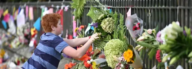 A child leaves a tribute at a memorial for victims in Christchurch