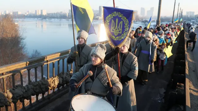 Люди з барабанами і прапорами на мосту