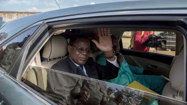 Maurice Kamto fait signe de la main à ses militants depuis sa voiture.