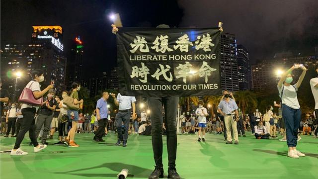 香港維多利亞公園足球場上一位參與「六四"集會人士高舉「反修例」標語（4/6/2020）