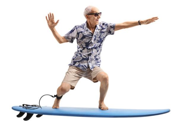 Hombre mayor simula surfear.