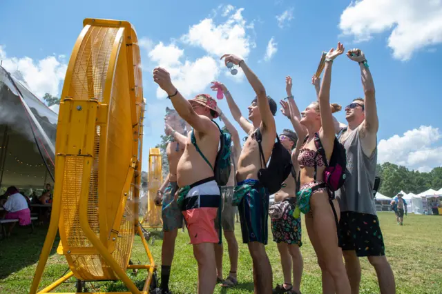 Mahalarta wani biki na waƙoƙi da kimiyya na Bonnaroo a yayin da suka tsaya a tsaye kusa da wata ƙatuwar fanka inda suke shan iska sakamakon zafin da ake yi a birnin Manchester da ke Jihar Tennessee ta Amurka.