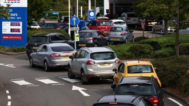A line of vehicles queue to fill up at a Tesco petrol station in Camberley, west of London on September 26, 2021