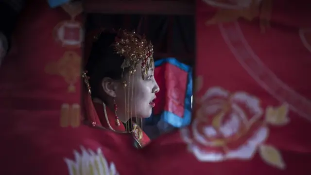 หญิงชาวจีนแต่งกายในชุดแต่งงานตามประเพณี