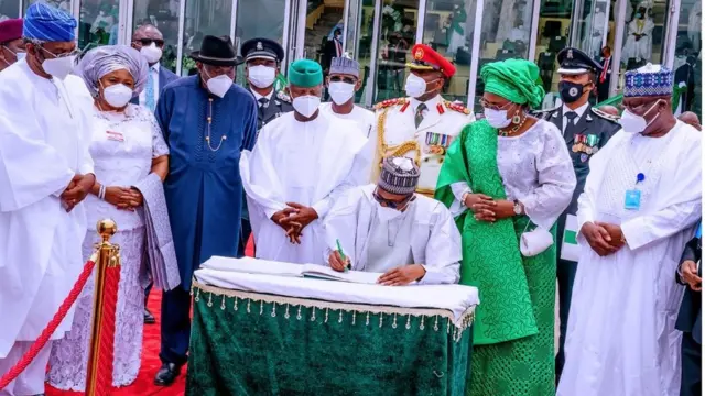 Aisha Buhari duro pẹlu awọn eekan ilu lasiko ti Aarẹ Buhari n buwọlu iwe nibi ayẹyẹ ọgọta ọdun ti Naijiria gba ominira.