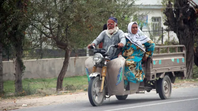 Мужчина и женщина на мотоцикле с прицепом