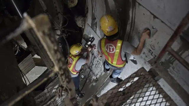 พนักงานในชุดป้องกันภัยที่มีตราสัญลักษณ์ของ บมจ. อิตาเลียนไทย กำลังทำงานในโครงการก่อสร้างรถไฟฟ้าสายสีน้ำเงิน ซึ่งเป็นโครงการรับเหมาก่อสร้างของบริษัทแห่งนี้