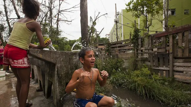 Criança toma banho ao ladojogo infantil grátisum esgoto na Cidadejogo infantil grátisDeus, no Riojogo infantil grátisJaneiro