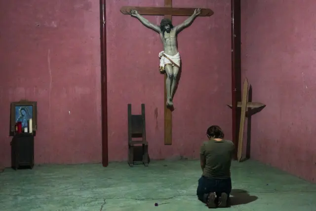 Migrante rezando en un refugio