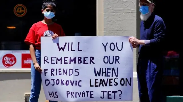 Refugee activists hold a sign reading: 'Will you remember our friends when Djokovic flies out on his private jet'