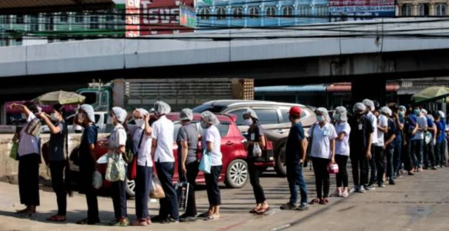 People queue to be tested for the COVID-19 coronavirus at a seafood market in Samut Sakhon on December 19, 2020 after some new cases of local infections were detected and linked to a vendor at the market.
