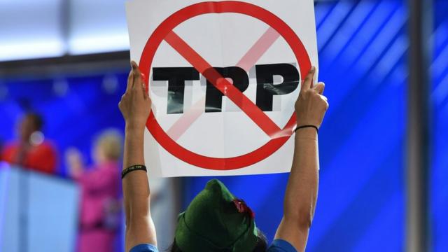 Mujer con cartel que dice "TPP" tachado.