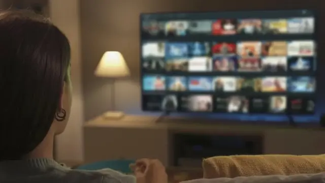 Una mujer mira la televisión.