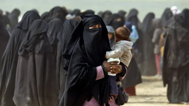 শিশু কোলে এক নারী