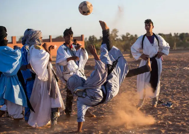 Locals play football during the 15th International Nomad Festival in Mhamid el-Ghizlane in Morocco's southern Sahara desert on March 24, 2018. / AFP PHOTO / FADEL SENNA (Photo credit should read FADEL SENNA/AFP/Getty Images)