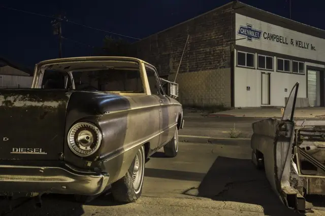 مركز لصيانة السيارات أمامه سيارة قديمة