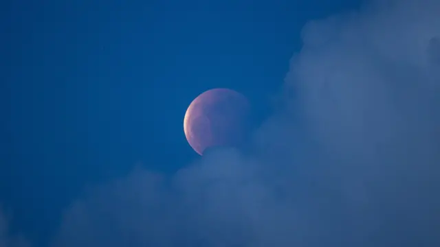 A "super blood moon" rises over the South China Sea during a moon eclipse in Hong Kong, China, 26 May 2021