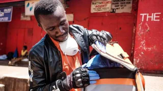 A Jumia Food employee, a global delivery service, collect the orders from Nakasero market in Kampala on April 1, 2020
