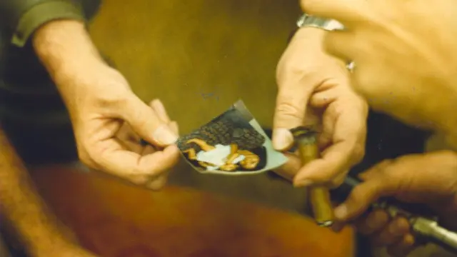 Las manos de Fidel Castro sostienen un puro y una foto de la esposa y la hija de Alpert en 1979. (Foto: Jon Alpert / Keiko Tsuno)