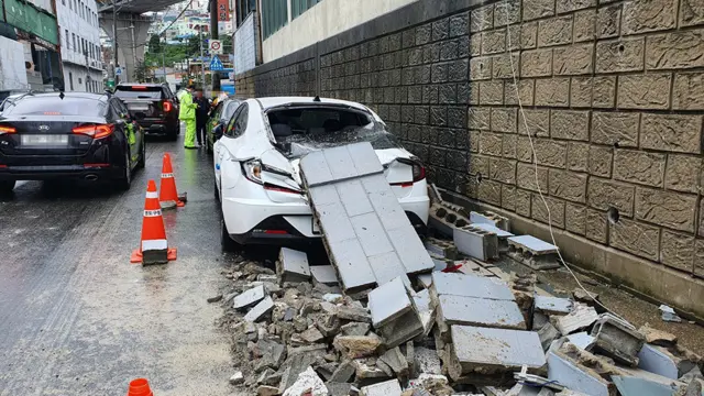 부산에서 한 건물의 벽면이 무너지면서 차량 2대가 파손됐다