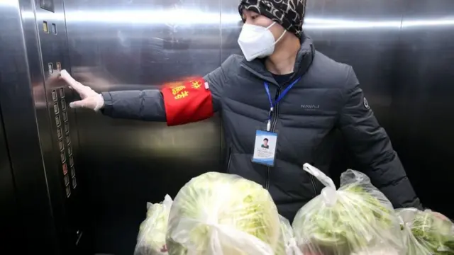 Tình nguyện viên và nhân viên đi phân phát các túi rau