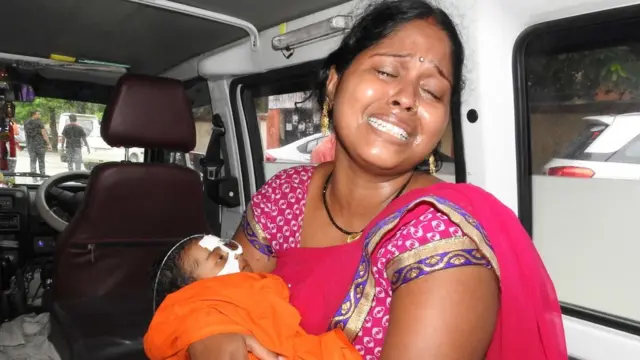 बच्चे को गोद में लिए बिलखती महिला