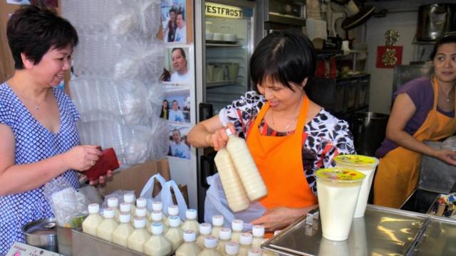 Mulher asiática compra leite