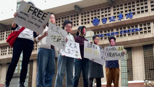 Defensores de los activistas con máscaras de Huang frente a la estación de Taipéi