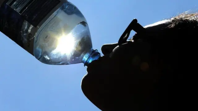 Mujer bebiendo una botella de agua.
