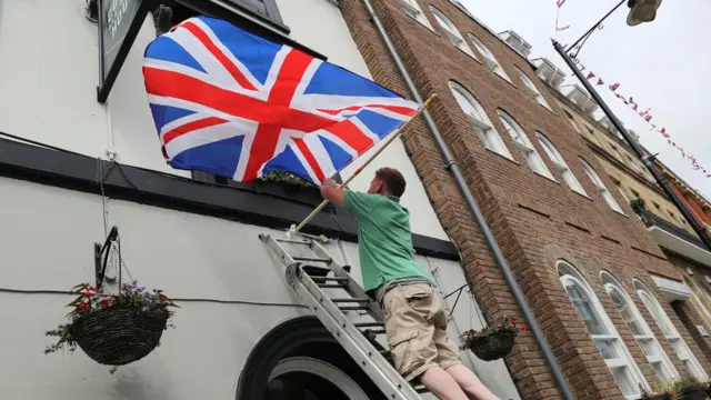 Человек украшает дом флажками